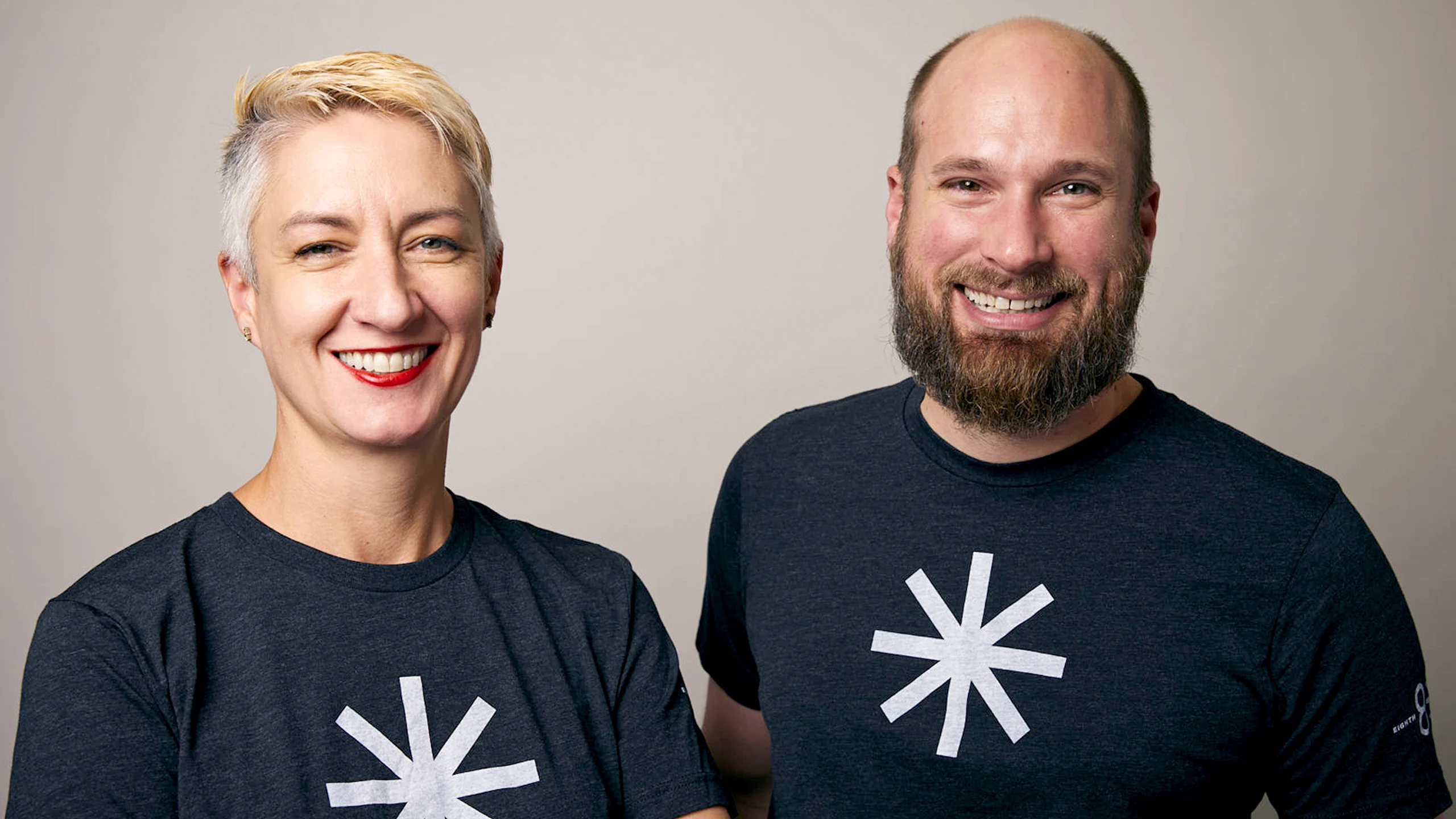 Two people wearing Eighth Light branded t-shirts