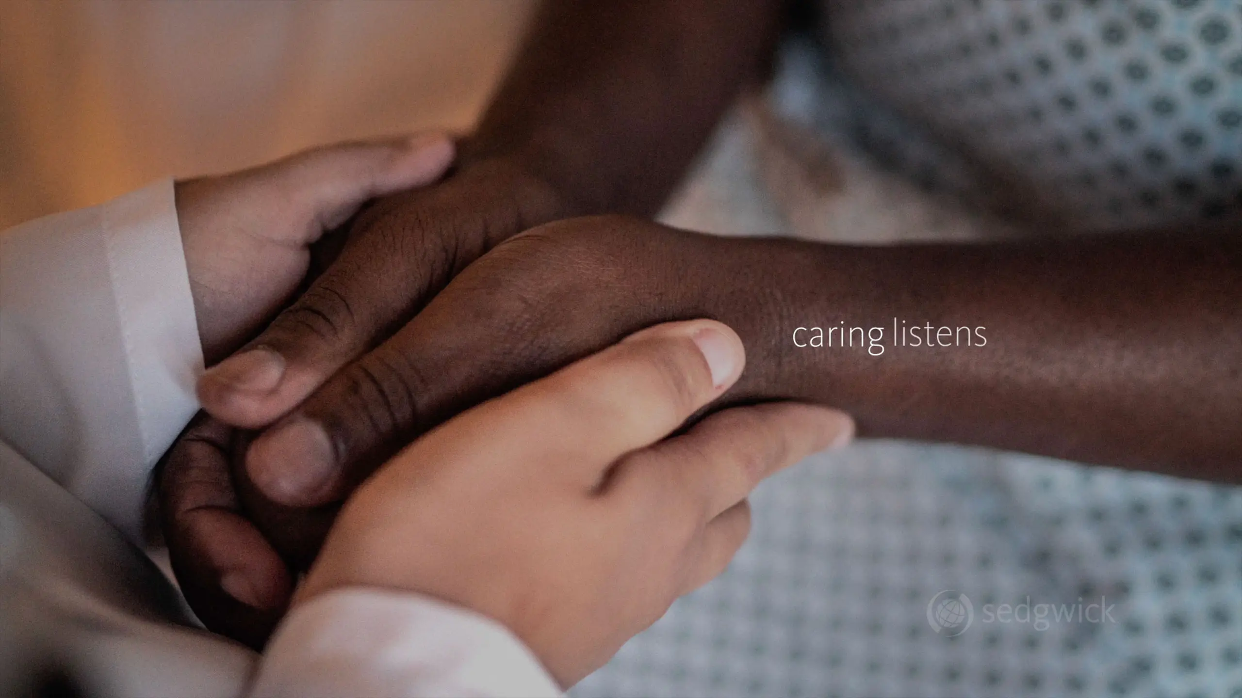 Two hands gently hold another, displaying empathy and care. The text "caring listens" highlights the compassionate connection between them.