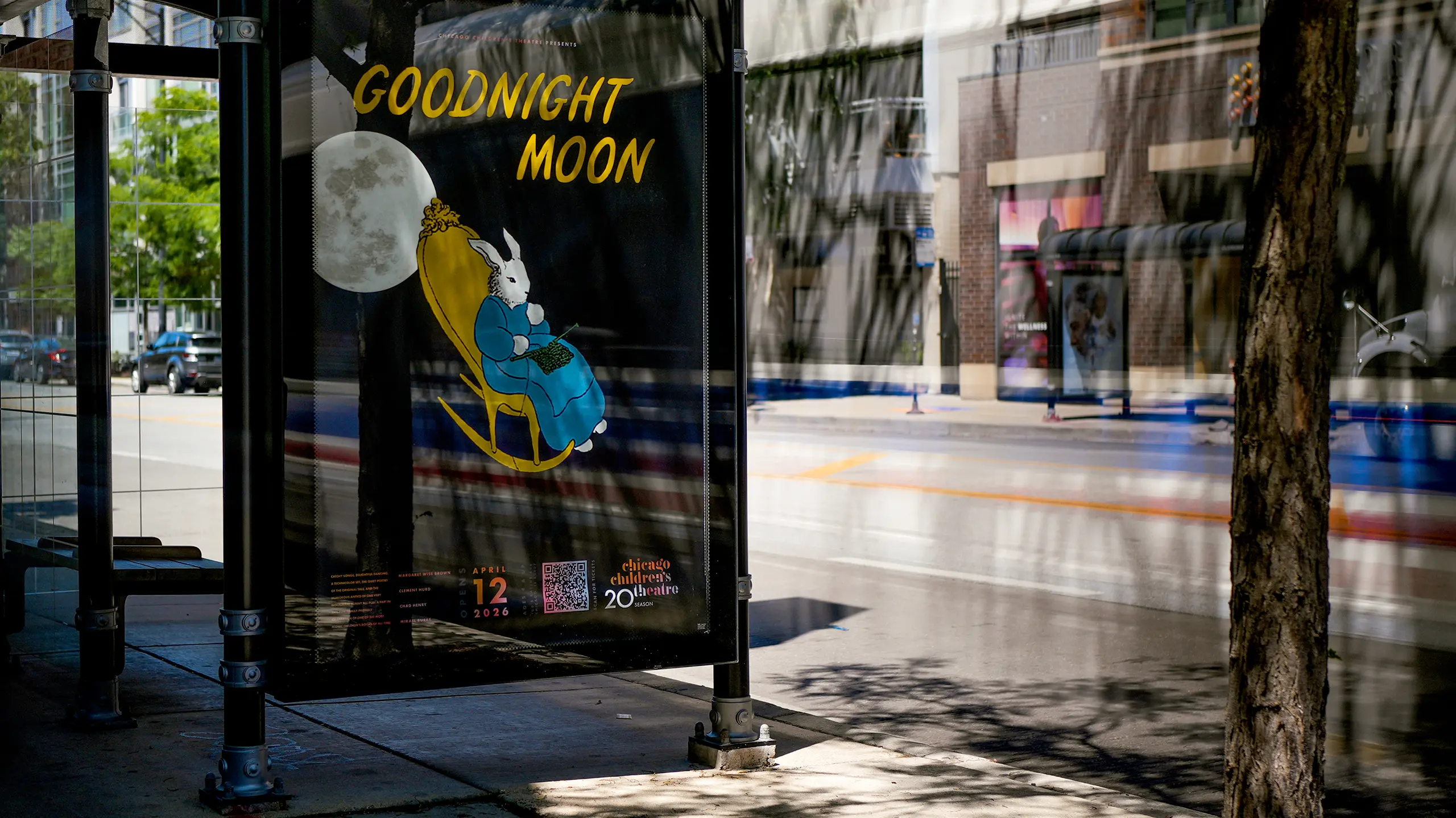 Bus stop poster for Chicago Children's Theatre of "Goodnight Moon" with a rabbit in a rocking chair against a large moon backdrop for