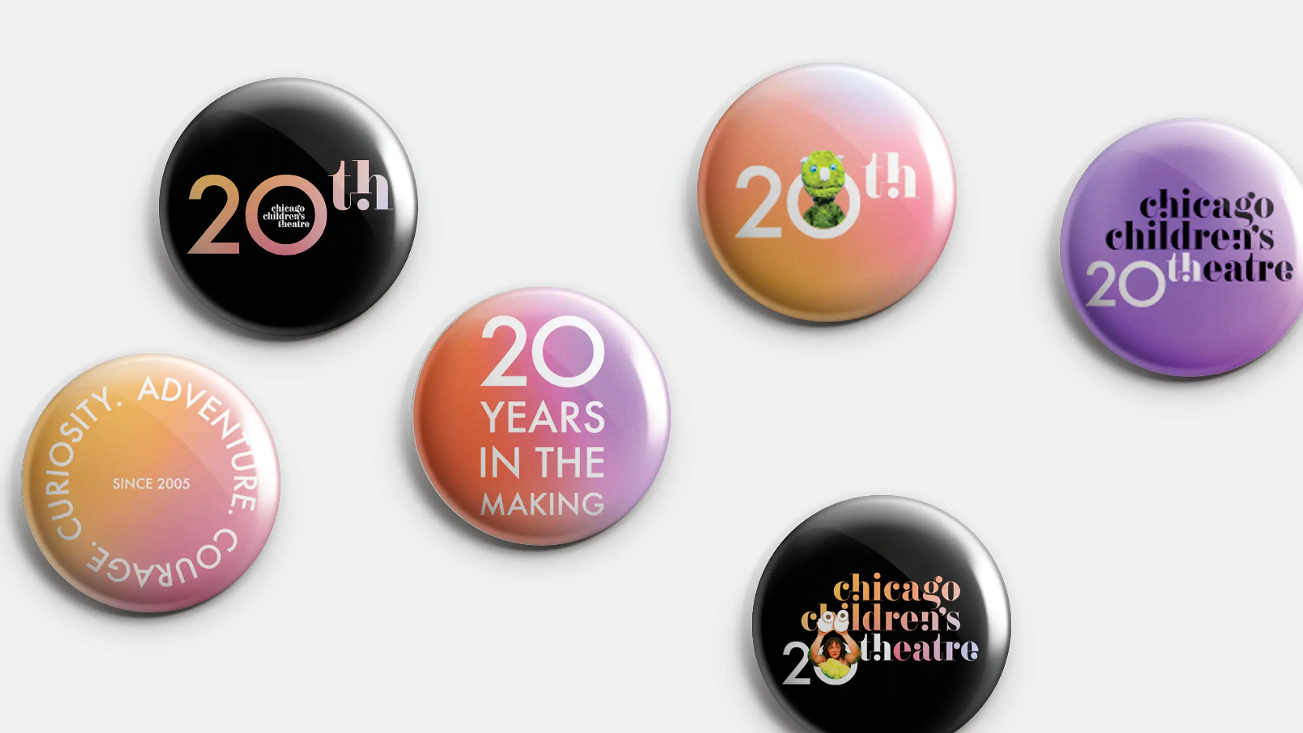 A set of six commemorative buttons celebrating 20 years of a theater. Designs feature phrases like "20 Years in the Making" and vibrant gradient colors.